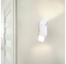 Lampă de perete albă cu design cubic lângă o ușă