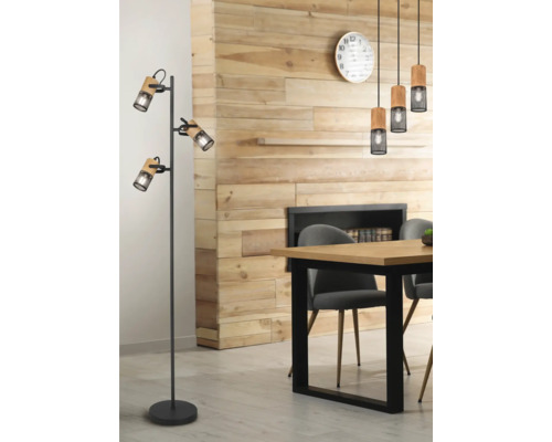 Cameră de zi cu perete din lemn, masă de sufragerie cu scaune, lămpi suspendate și lampă de podea cu trei spoturi