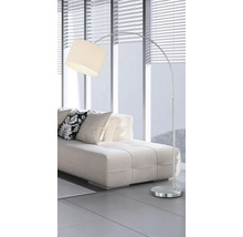 Lampă arcuită metalică cu abajur lângă o canapea