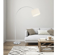 Lampă arcuită metalică cu abajur din material textil lângă o canapea într-un living