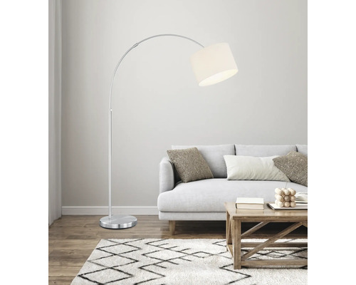 Lampă arcuită metalică cu abajur din material textil lângă o canapea într-un living