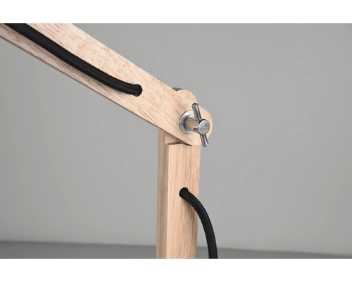 Prim-plan al unei lămpi din lemn cu cablu negru și conexiune metalică.