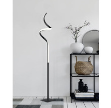 Lampă decorativă de podea cu design curbat în sufragerie lângă un raft.