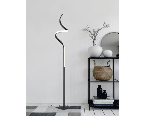 Lampă decorativă de podea cu design curbat în sufragerie lângă un raft.