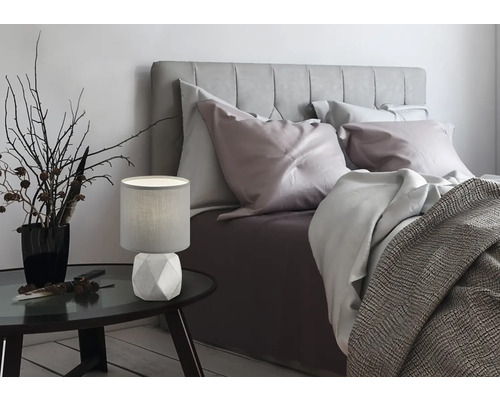 Dormitor cu pat, noptieră și lampă de masă