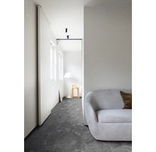 Cameră luminoasă cu canapea, covor și design minimalist.
