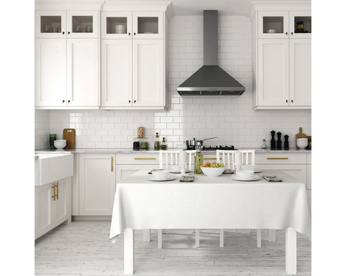 Bucătărie luminoasă cu dulapuri albe, hotă de aragaz și masă aranjată