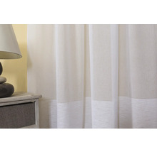 Material decorativ alb pentru perdele lângă lampa de noptieră