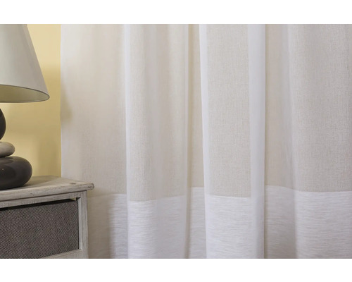 Material decorativ alb pentru perdele lângă lampa de noptieră