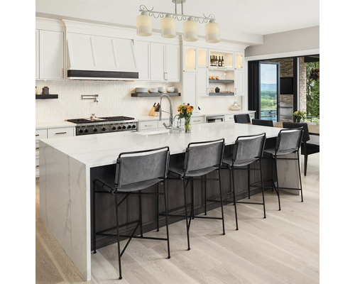 Bucătărie luminoasă cu insulă, scaune de bar și aparate moderne.