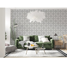 Cameră de zi cu canapea verde, tapet geometric, covor și elemente decorative pentru un ambient luminos și organizat.