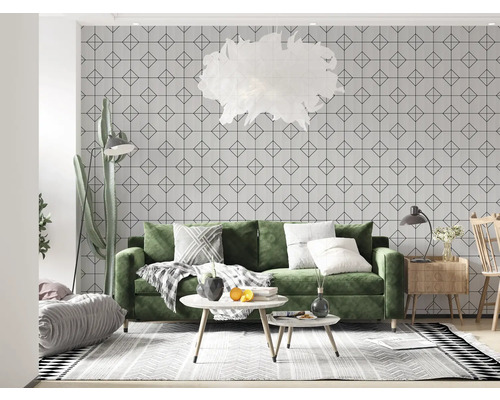 Cameră de zi cu canapea verde, tapet geometric, covor și elemente decorative pentru un ambient luminos și organizat.