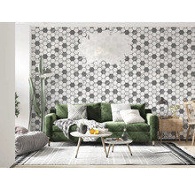 Living luminos cu tapet hexagonal gri, canapea verde și elemente din lemn