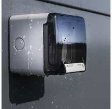 Stropi de apă pe un dozator de săpun montat pe perete