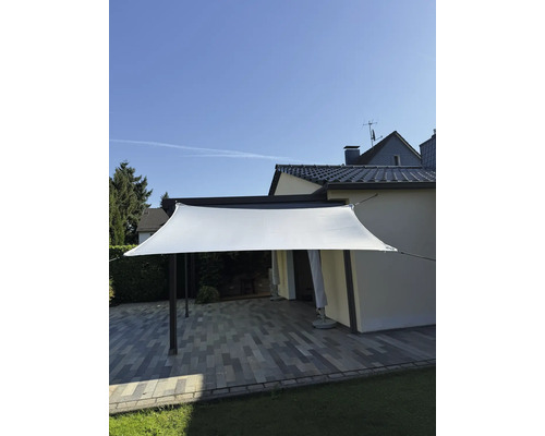 Pânză de umbrire deasupra unei terase cu podea de piatră