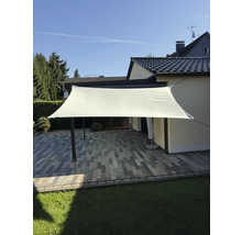 Copertină dreptunghiulară de soare deasupra unei terase cu pavaj și gazon.