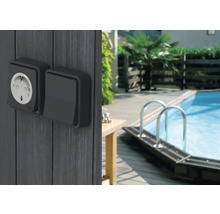 Priză de exterior și întrerupător pe un perete de lemn lângă o piscină