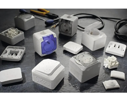 Imagine cu diverse prize și întrerupătoare albe montate la suprafață, precum și unelte.