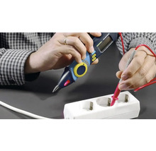 Persoană care testează o priză cu un multimetru