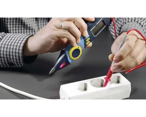 Persoană care testează o priză cu un multimetru