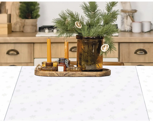 Aranjament decorativ cu lumânări, crenguțe și față de masă cu model de fulgi de nea