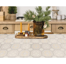 Masa decorativă cu o față de masă cu model, lumânări și ramuri de brad într-o vază