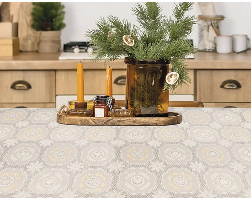 Masa decorativă cu o față de masă cu model, lumânări și ramuri de brad într-o vază