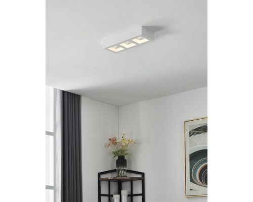 Lumină de plafon cu trei lămpi într-un living modern.