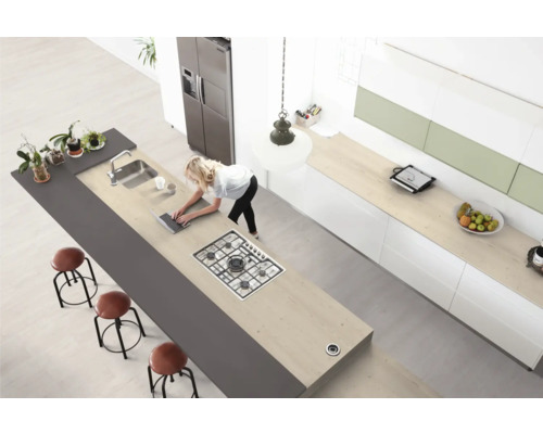 Bucătărie modernă cu insulă de gătit, chiuvetă, scaune de bar și femeie cu laptop