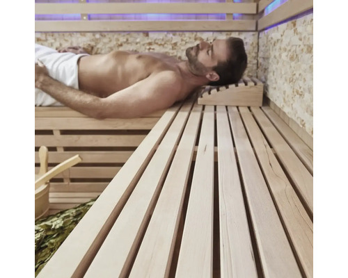Bărbat relaxându-se într-o saună cu bănci din lemn și accesorii.
