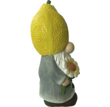 Gnom de grădină cu lămâie drept cap și floarea-soarelui în mână