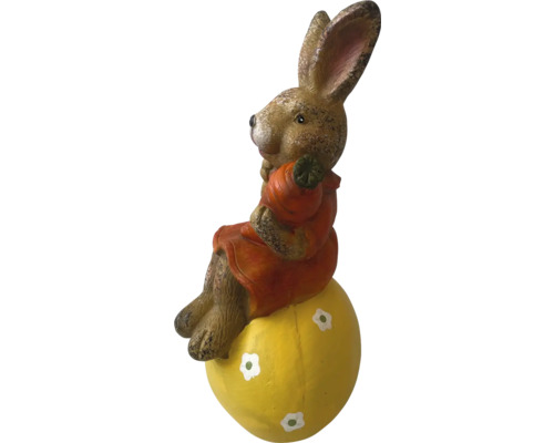 Iepure de Paște pe un ou galben ca decorațiune de grădină