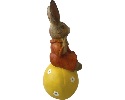 Figurină de iepuraș de Paște șezând pe un ou galben ca decorațiune