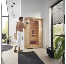 Bărbat care operează o saună cu infraroșu Home Deluxe într-o baie