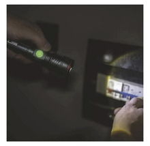 O persoană luminează o cutie de siguranțe cu o lampă de inspecție.