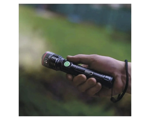 O mână ține o lanternă Emos neagră care luminează.