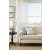 Living cu canapea, perne, lampă și fereastră