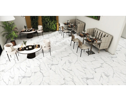Vedere interioară cu podea cu gresie aspect marmură, mese și locuri de ședere.