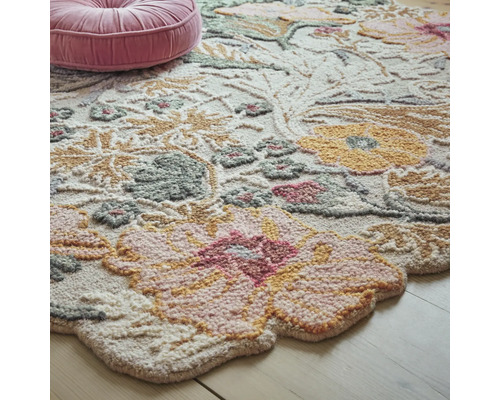 Detaliu al unui covor cu model floral și o pernă