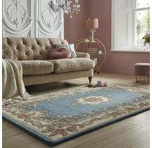 Cameră de zi cu canapea și covor albastru cu model floral