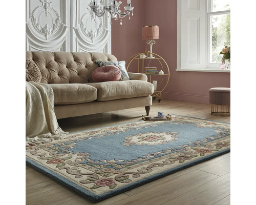 Cameră de zi cu canapea și covor albastru cu model floral