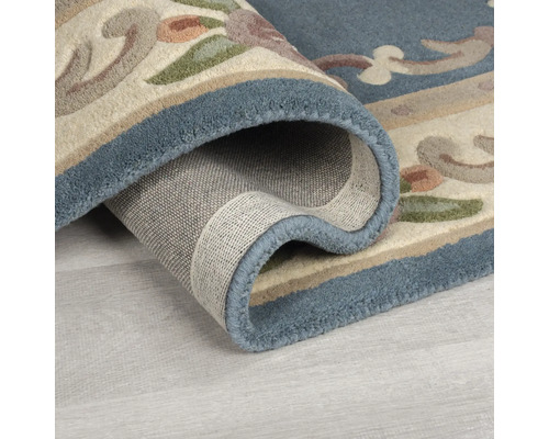Imagine detaliată cu un covor rulat, cu model floral și bordură albastră
