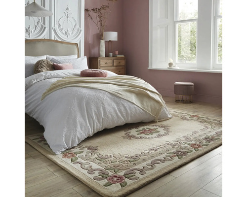 Dormitor cu pat, noptieră și un covor bej cu model floral