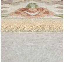 Prim-plan al unui covor cu motiv floral și suprafață texturată.