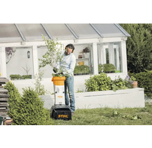 Un bărbat folosește un tocător de grădină Stihl în grădina sa.