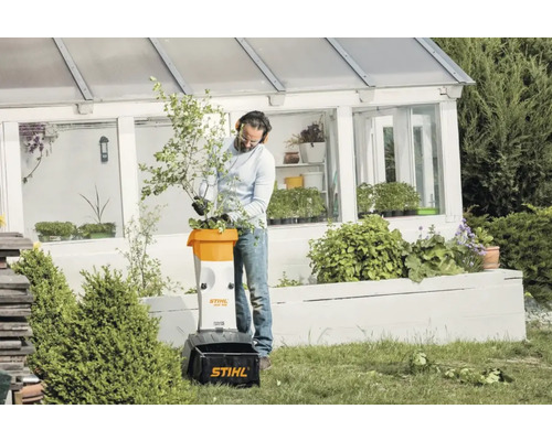 Un bărbat folosește un tocător de grădină Stihl în grădina sa.