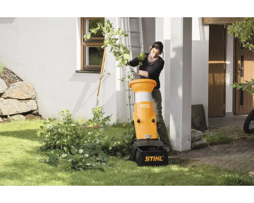 O femeie folosește un tocător de grădină STIHL pentru a mărunți deșeurile de grădină.