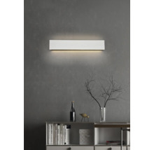 Lumină de perete metalică deasupra unui bufet cu decorațiuni pe un perete gri