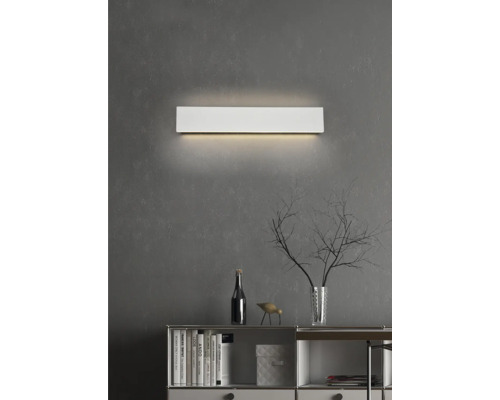 Lumină de perete metalică deasupra unui bufet cu decorațiuni pe un perete gri