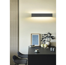 Lumină de perete deasupra unei mese cu decorațiuni într-o cameră luminoasă.